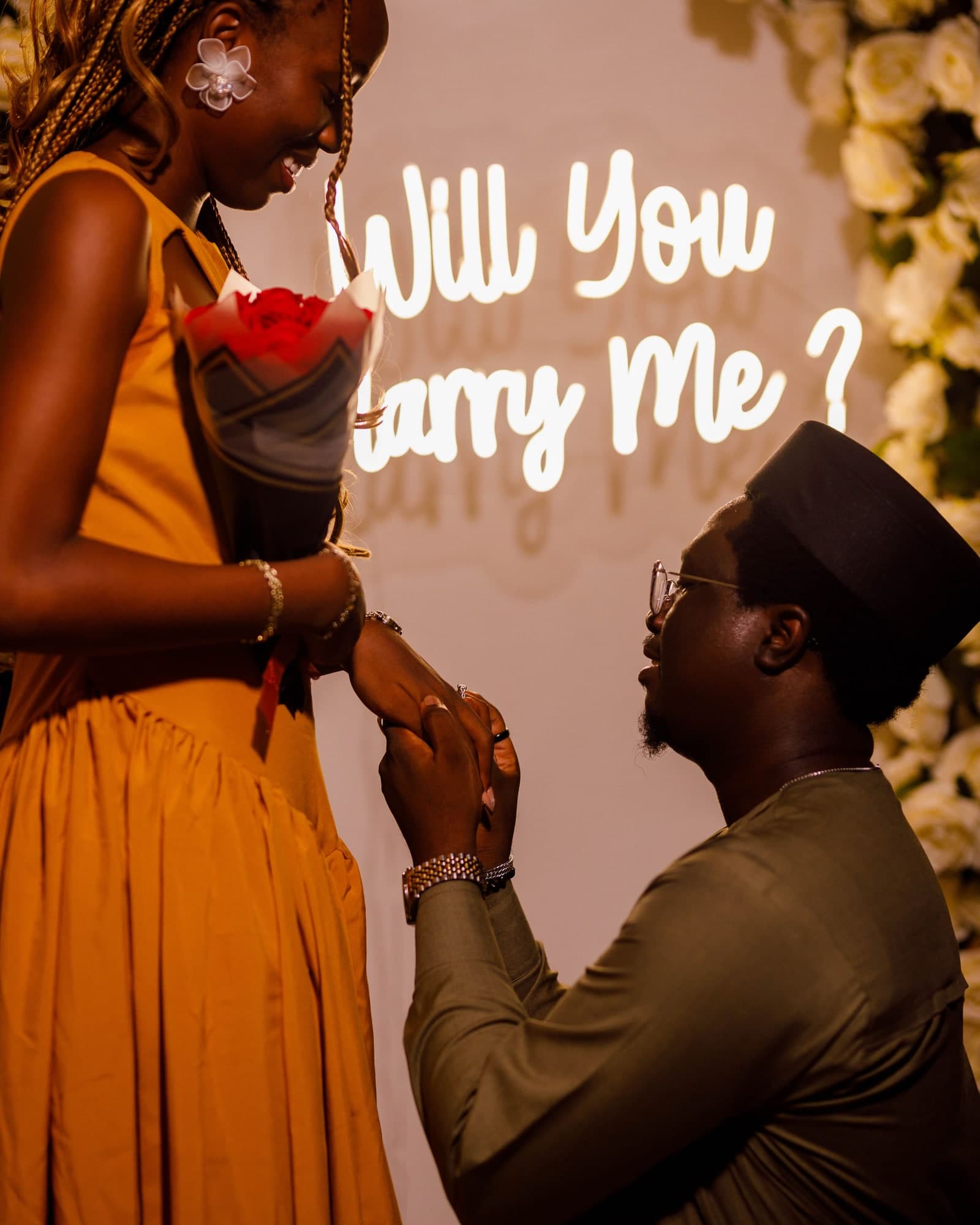 Jeremiah proposing to Esther-Praise beneath a glowing will you marry me sign